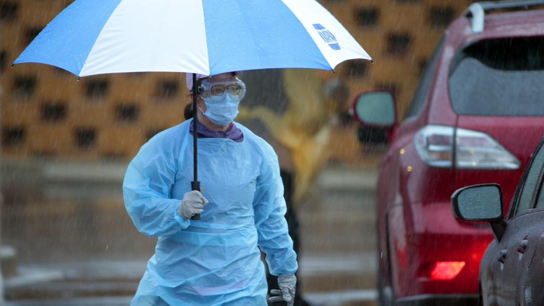 Medical workers stand in steady rain to test people for coronavirus at Mercy site in Chesterfield